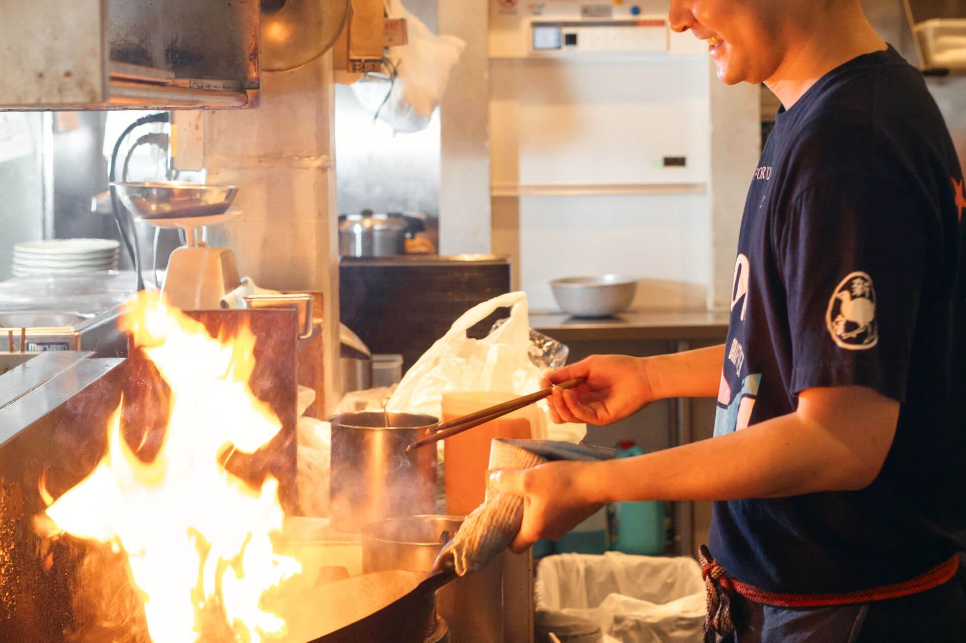 厨房で炒め物を作るやんばるのスタッフ